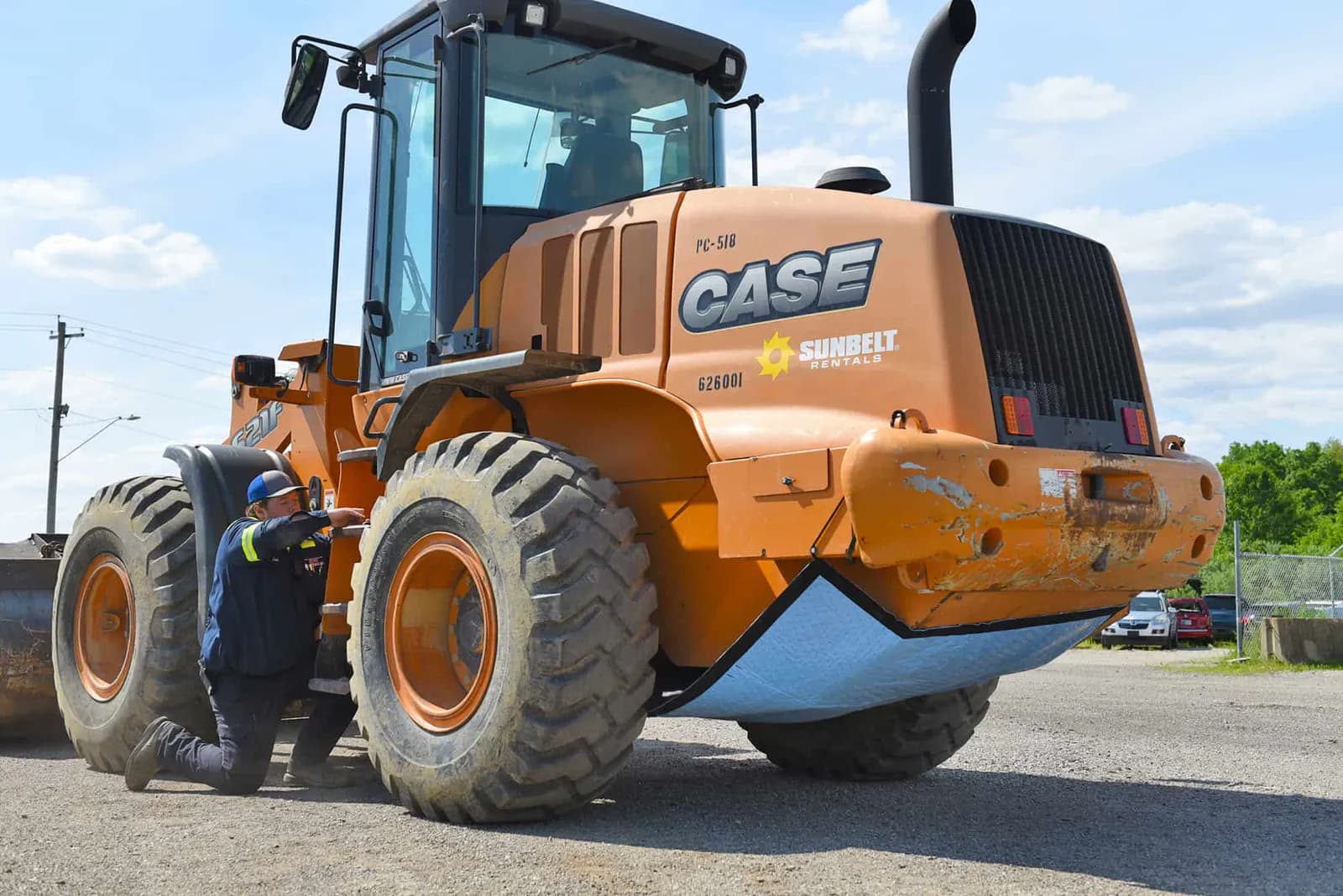 Spill Diaper fitted beneath the rear of a wheel loader, with the blue barrier outward